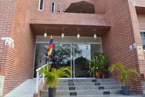 a flag in front of a brick building with stairs at Hotel Villa Playa Grande in Playa Grande