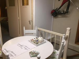 une table et des chaises blanches avec une table blanche et une chambre dans l'établissement Gezellige zolder in Wassenaar met dakterras, à Wassenaar