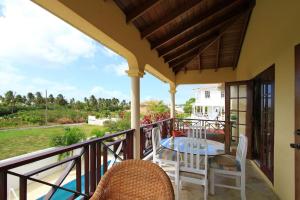 patio con mesa y sillas en el balcón en Sungold House Barbados en Saint Peter