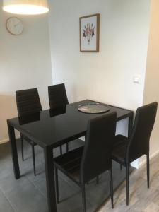 a black dining room table with black chairs and a clock at Heleenkatu 3 a 1 oma sauna autokatos omassa pihassa in Seinäjoki