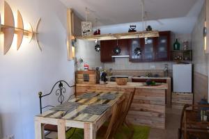 Una cocina con una mesa de madera y un refrigerador. en Casa D Amélia, en Óbidos