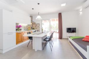 a kitchen and living room with a table and chairs at Beachside Villa Marko in Milna