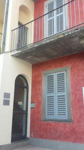 a red and white building with a balcony and a door at Casa Vacanza Bergamo Centro in Bergamo