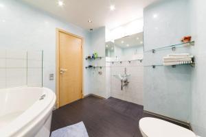 a bathroom with a tub and a toilet and a sink at Brivibas LUX in Riga