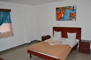 sypialnia z łóżkiem i obrazem na ścianie w obiekcie Hotel Villa Playa Grande w mieście Playa Grande