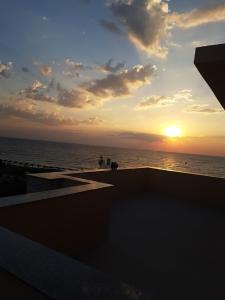 a sunset over the ocean from a building at Sara in Vama Veche