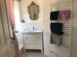 a bathroom with a sink and a mirror and towels at Ferienwohnungen im Lüftlmalereck, Mussldomahaus in Oberammergau +43 photos