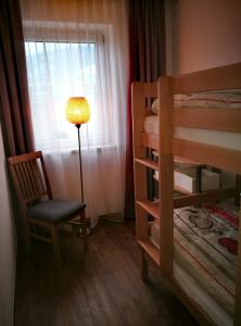 フューゲンにあるApartment Koglerのベッドルーム1室(二段ベッドの横にランプと椅子付)
