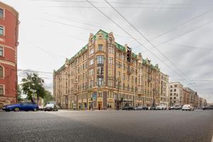 un gran edificio con coches estacionados frente a él en Mom, I'm Home, en San Petersburgo