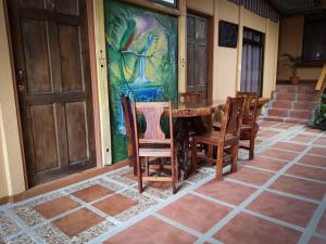 une table et des chaises à côté d'un mur orné d'une peinture dans l'établissement Greemount Hotel, à Monteverde Costa Rica