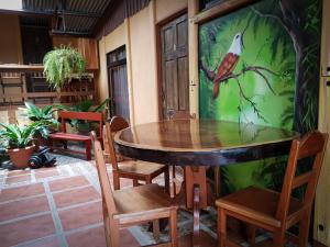 uma mesa de jantar com cadeiras e um pássaro pintado na parede em Greemount Hotel em Monteverde