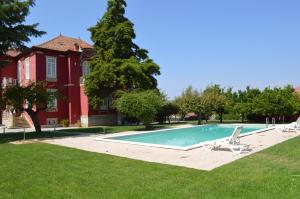 a swimming pool in a yard next to a house at Casa Vermelha in Vila Nova de Foz Coa