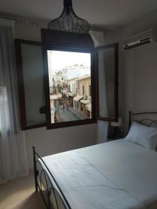a bedroom with a bed and a large window at Prokymaia Apartment 2 in Áyios Andónios
