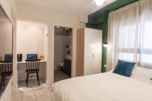 a bedroom with a bed and a desk and a chair at Golda Vacation Rentals in Jerusalem