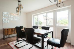 a dining room with a table and black chairs at The Century Chalet - Contemporary 2BDR Townhouse with Parking in Oxford