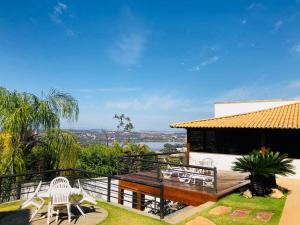 a house with a deck with two chairs and a table at Casa De Lagoa Santa in Lagoa Santa