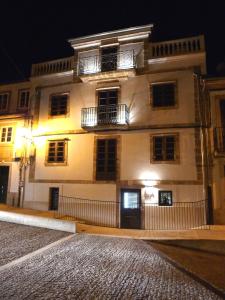 un gran edificio blanco con 2 balcones por la noche en Blanco Apartamentos Turísticos en Santiago de Compostela
