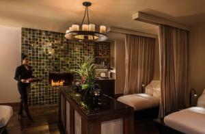 a woman standing in a hotel room with a fireplace at The Peninsula Chicago in Chicago