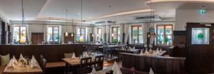 a dining room with tables and chairs and windows at Hotel Drei Tannen in Moosburg