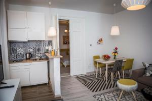 eine Küche und ein Wohnzimmer mit Tisch und Stühlen in der Unterkunft Reghin Guest House in Reghin