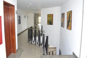 a hallway with a staircase with chairs and paintings on the wall at Hotel Villa Playa Grande in Playa Grande