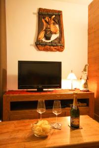 ein Wohnzimmer mit einem TV und 2 Weingläsern auf dem Tisch in der Unterkunft Time to Ski - Aramis in Sainte-Foy-Tarentaise