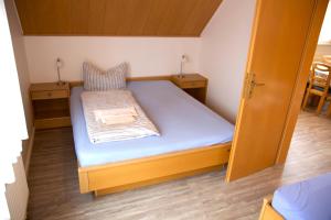 ボルクムにあるBORKUMUNTERKUNFT - WOH7 - IM HERZEN DER INSELの小さな部屋(テーブル2台付)の小さなベッド1台分です。