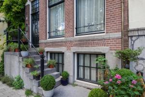 um edifício de tijolos com escadas e vasos de plantas sobre ele em SeventyFive em Amsterdã