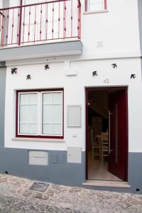 ラゴスにあるCasa das Andorinhasの白い家(赤いドア、バルコニー付)