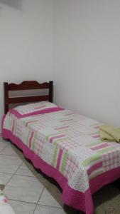 a bed with a pink and white blanket on it at Casa de Férias Mãe Maria in Aparecida +6 photos