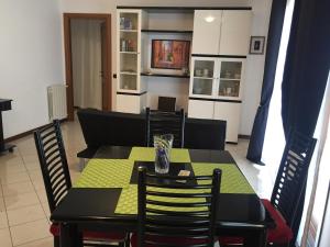 uma sala de jantar com uma mesa verde e cadeiras em Via Acquedotto n. 66, Condominio "Le Piramidi" em Olbia
