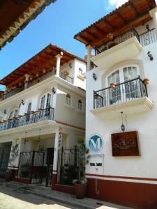 a white building with balconies and a sign on it at Hotel el Le&ntilde;ador in Mazamitla
