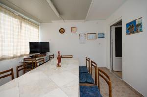 a living room with a table and a television at Apartment Stojna in Lopar
