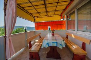 a table in the balcony of a house at Apartment Stojna in Lopar