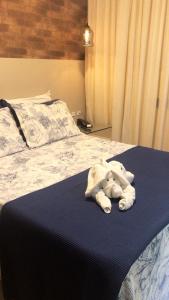 a stuffed elephant is laying on a bed at Hotel Ibicui in Rosário do Sul