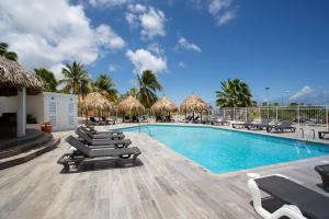 een zwembad met ligstoelen en een resort bij Bon Bini Seaside Resort Curacao in Willemstad