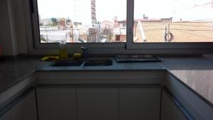 encimera de cocina con fregadero y ventana en Alvarado Departamentos en Salta