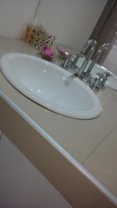 lavabo blanco en la encimera del baño en Alvarado Departamentos en Salta