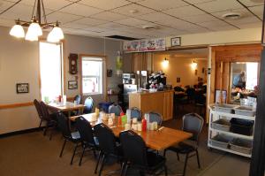 una sala da pranzo con tavoli e sedie in un ristorante di The Home Hotel a Boissevain