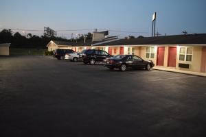 um parque de estacionamento com carros estacionados em frente a um edifício em White Oaks Motel Pennsville/Carneys Point em Pennsville