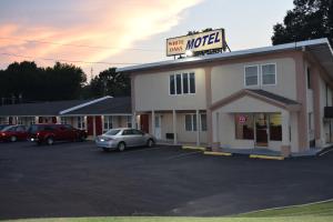 een hotel motel met een auto geparkeerd op een parkeerplaats bij White Oaks Motel Pennsville/Carneys Point in Pennsville