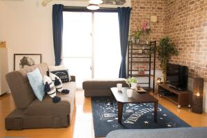 a living room with a couch and a tv at Guesthouse TT Koza in Okinawa City
