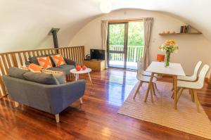 a living room with a couch and a table at Magic Cottages at Takou River in Kerikeri