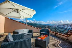 a patio with an umbrella and chairs and a table at Mansarda sopra il mare in San Marco dʼAlunzio