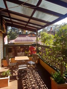 a patio with a table and chairs on a balcony at Bridgefield Guest House in Margaret River Town