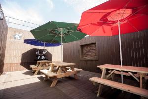 two picnic tables and two umbrellas on a deck at 24 Guesthouse Jeonju in Jeonju