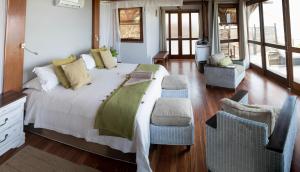 a bedroom with a large bed and chairs in it at Massinga Beach in Massinga