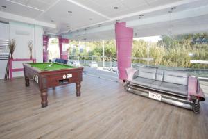 a room with a pool table and two chairs at Bayside Salgados in Albufeira
