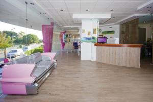 a waiting room with pink chairs and a counter at Bayside Salgados in Albufeira