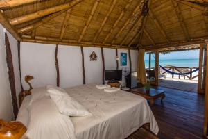 sypialnia z łóżkiem i widokiem na ocean w obiekcie Balihai Bungalows w mieście Canoas De Punta Sal